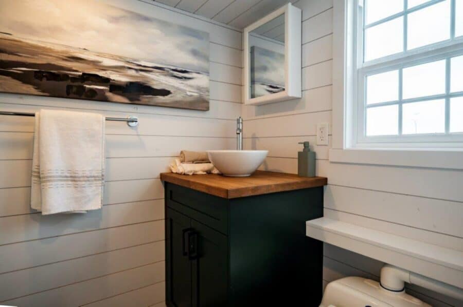 Compact tiny house bathroom with modern design and natural light.