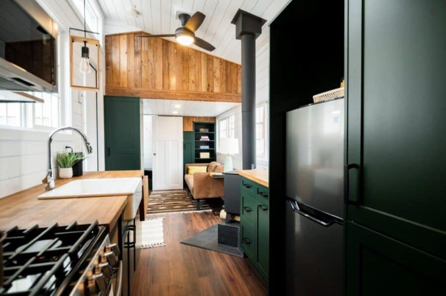 Modern tiny house interior with sleek green cabinetry and cozy living space.