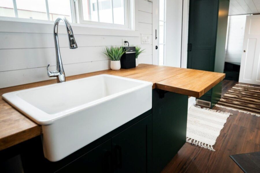 Compact farmhouse kitchen with farmhouse sink and wooden countertops.