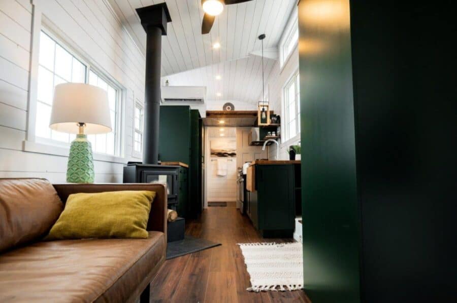 Interior view of a modern tiny house with cozy living space and compact kitchen.