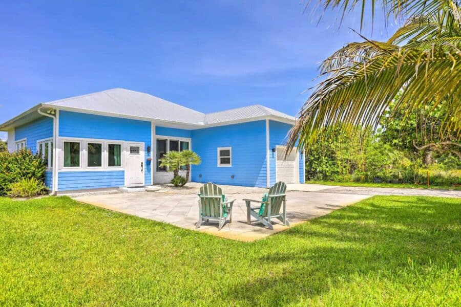Charming blue cottage on Hutchinson Island with lush lawn and tropical palm trees. Perfect small spa.