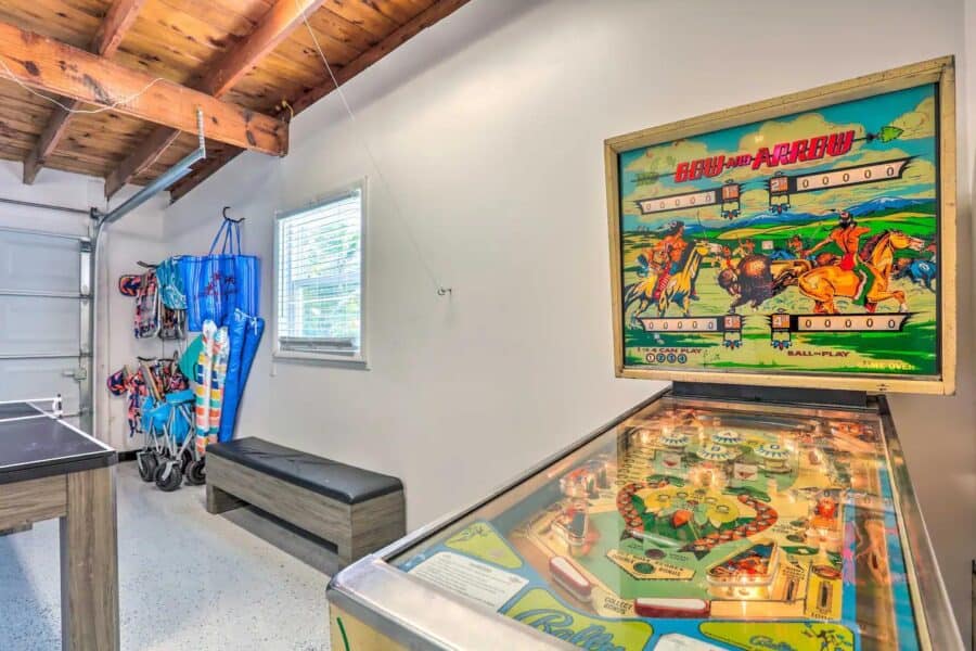 Cozy cottage interior with vintage pinball machine and beach-themed decor in Fort Pierce, Florida.