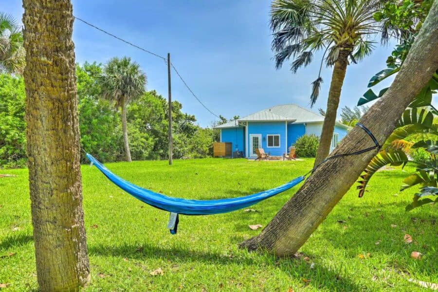 Hammock between trees overlooking a colorful cottage in Fort Pierce, Florida.