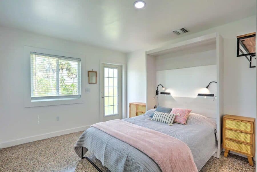 Bright and airy tiny house bedroom featuring large windows and minimalist decor. Perfect for small s.