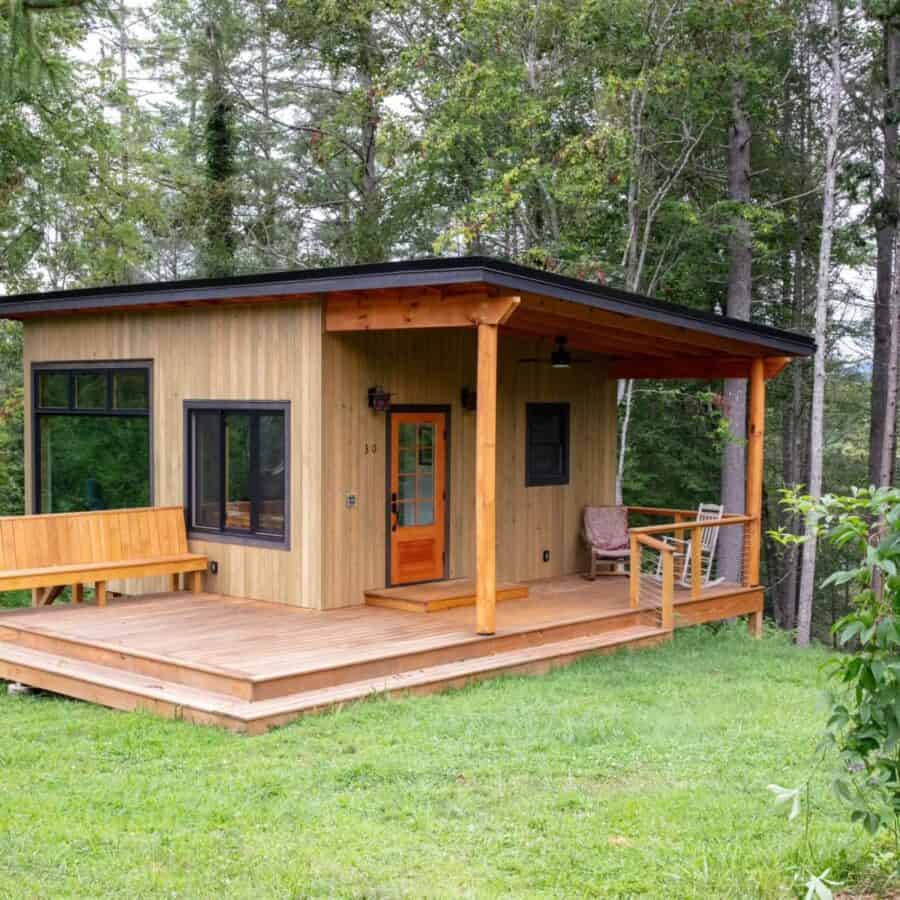 Modern tiny house cabin in North Carolina with wooden exterior and spacious porch.
