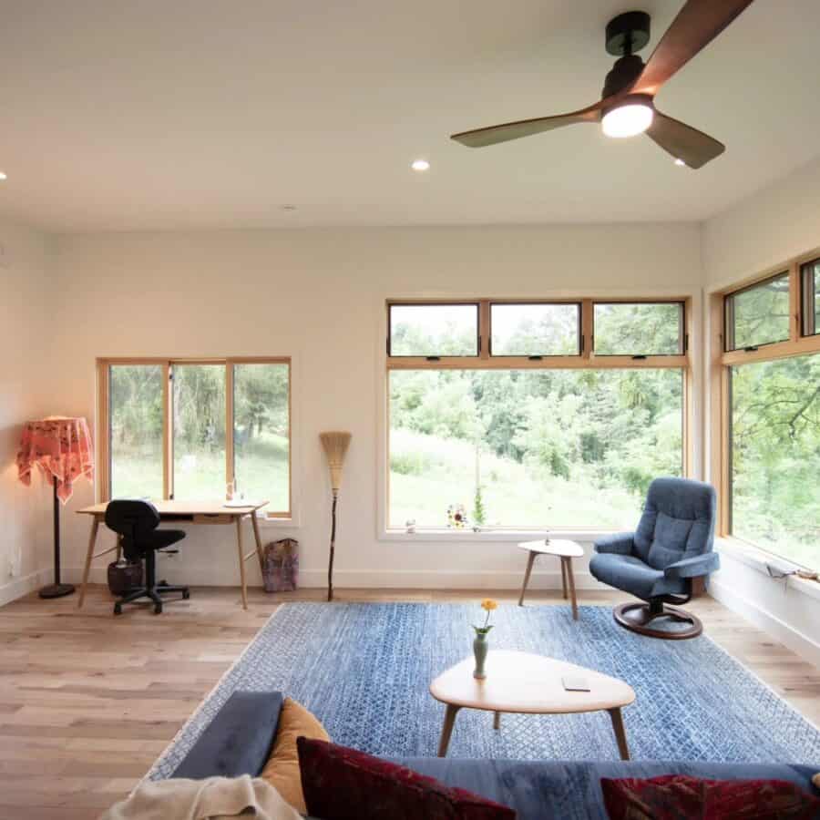 Bright tiny house interior with large windows and cozy seating in North Carolina.