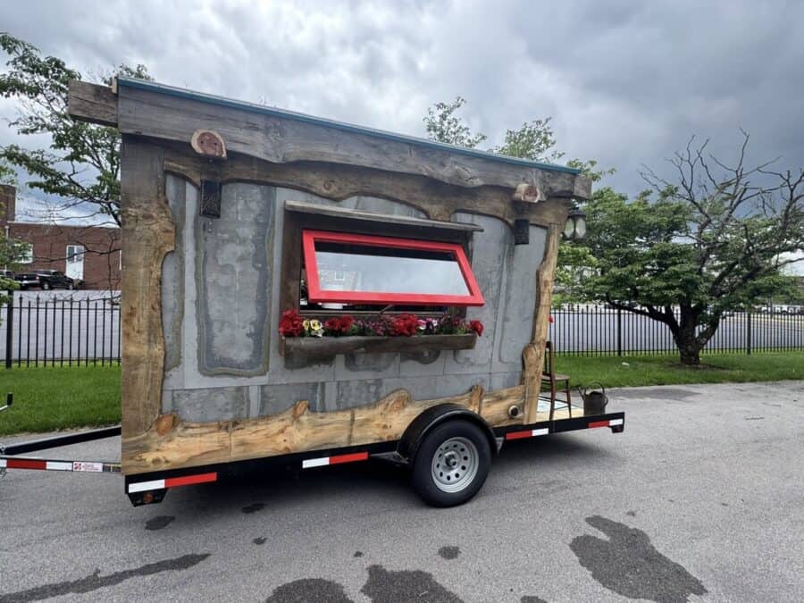 Colorful gypsy-style tiny house on wheels with vibrant window and decorative details.