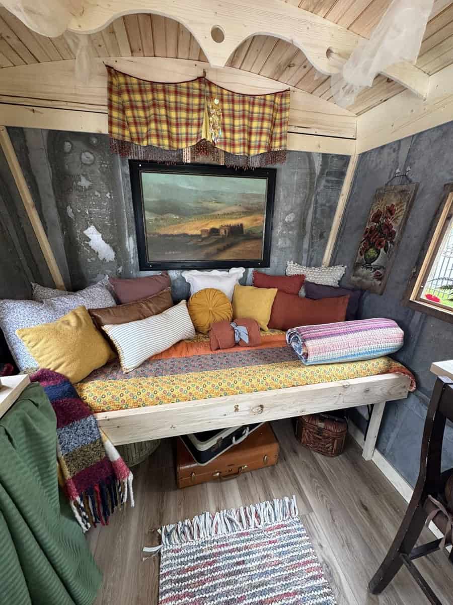 Charming tiny house interior with colorful cushions, rustic wood accents, and vibrant textiles.