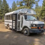 Compact skoolie bus converted into a tiny home with a cabin-like design.