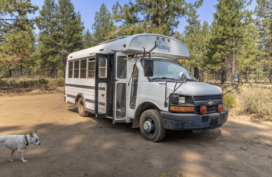 Compact skoolie bus converted into a tiny home with a cabin-like design.