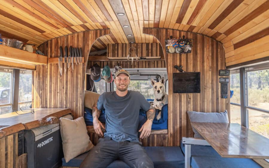 Cozy tiny house interior featuring wood accents, a man, and a dog, showcasing small space living.