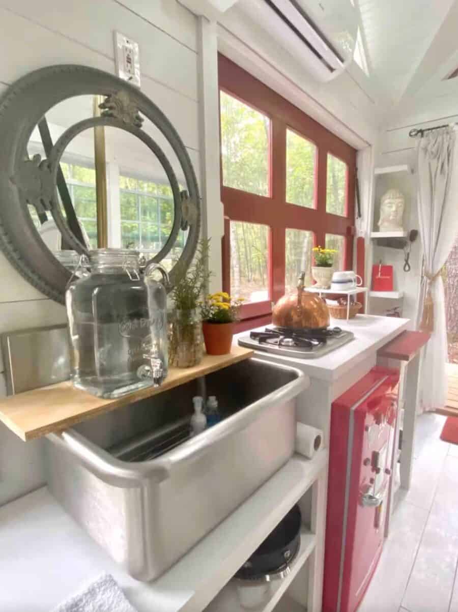 Firehouse Tiny House kitchen at Lake Oconee, Georgia, with bright red appliances and large windows.