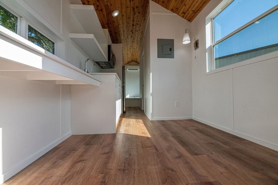 Bright, open interior of a 24' Jojo Bean Tiny Home with natural wood accents and large windows.
