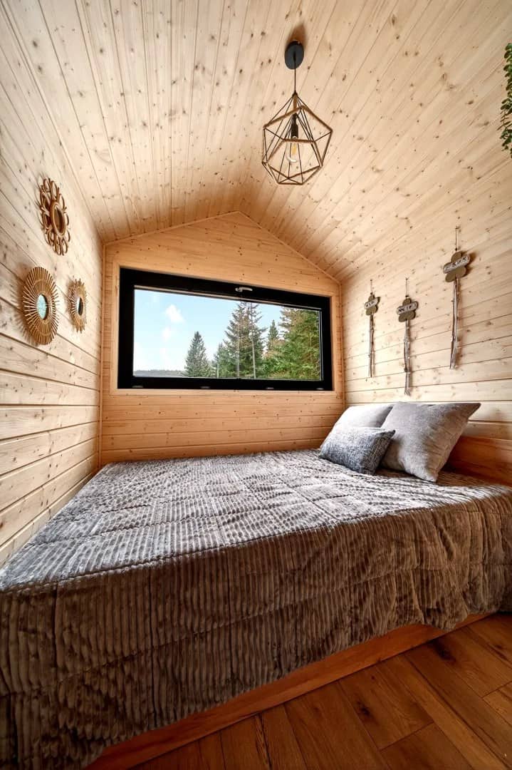 Justine bedroom with a geometric pendant light, double bed, and gable ceiling