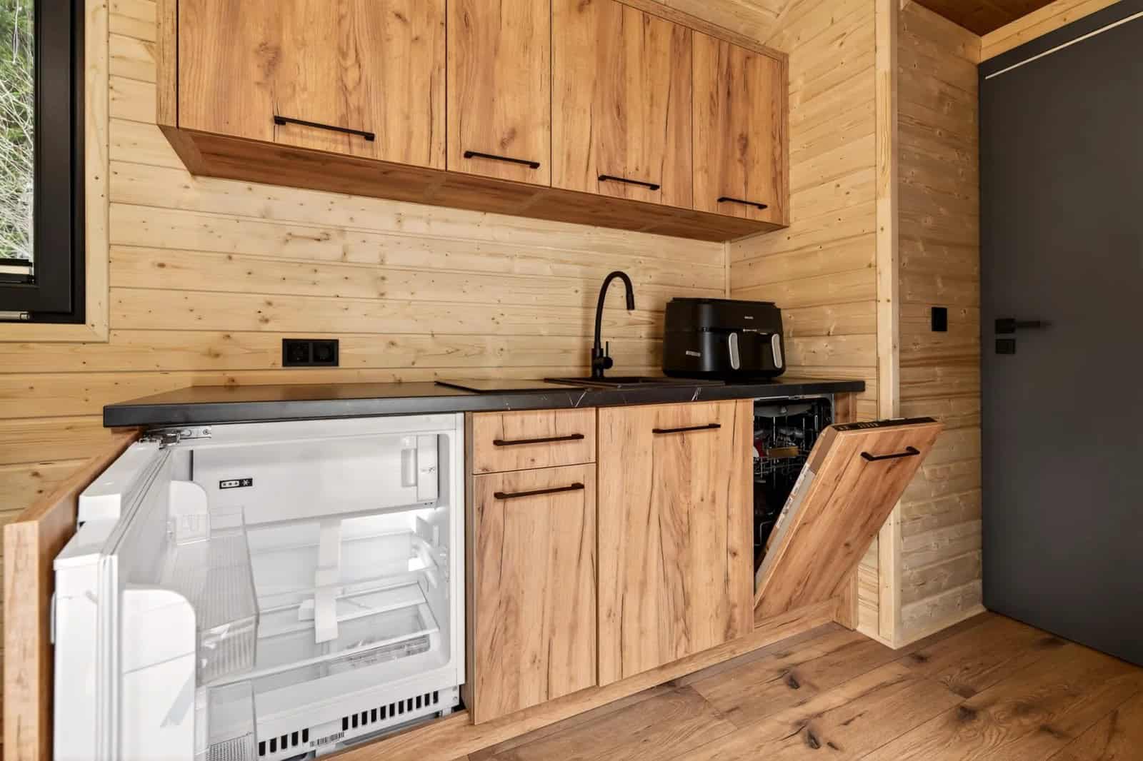 Justine kitchen with an integrated refrigerator, dishwasher, induction hob, and sink under a black counter