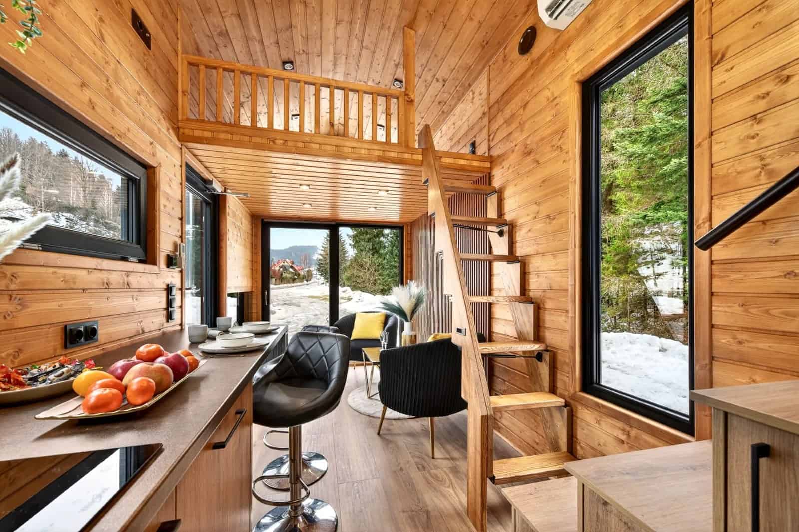 Katrin kitchen and breakfast bar with stools, a loft above, and glass doors to a snowy view