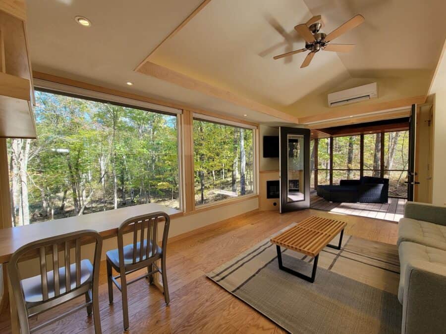 Cozy interior of a classic king XL tiny house with large windows overlooking Wisconsin lakefront.