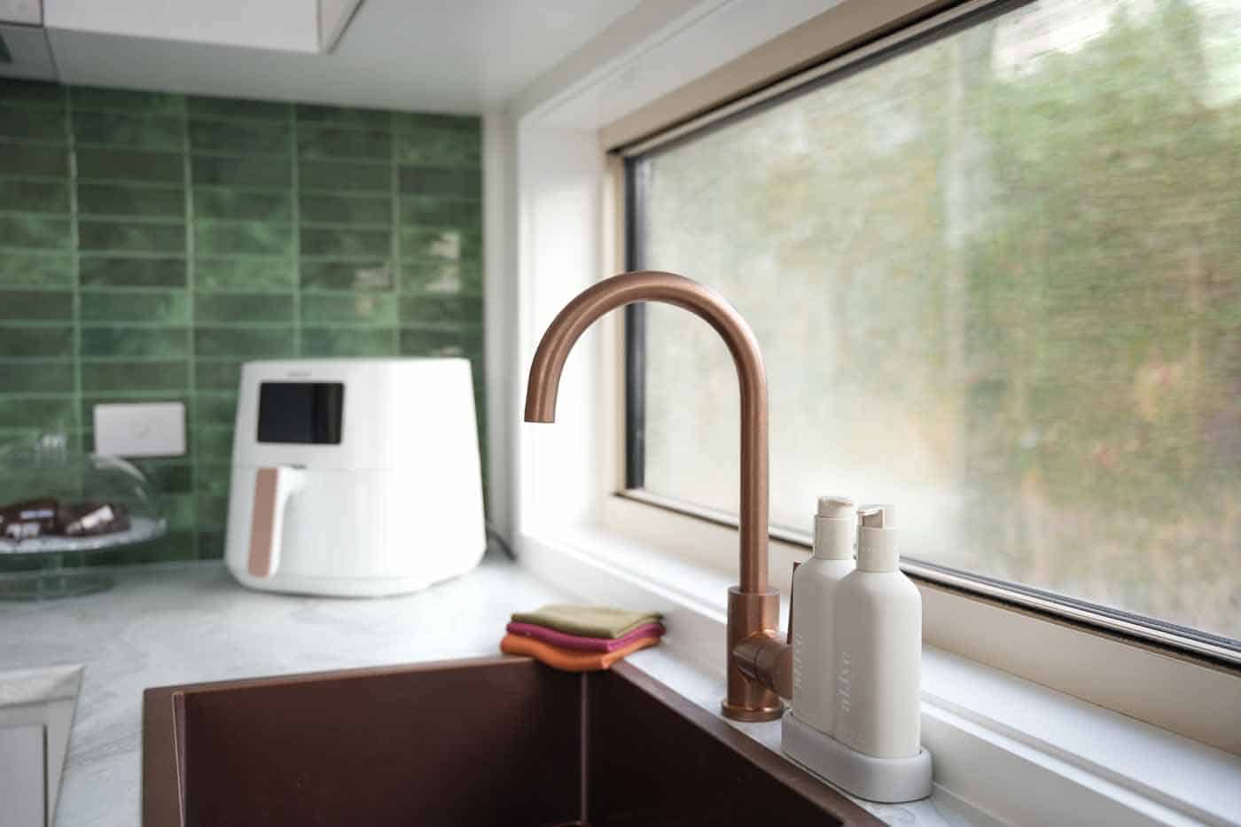Detail of the brushed copper kitchen tap and green tile splashback in the Kookaburra 2.0