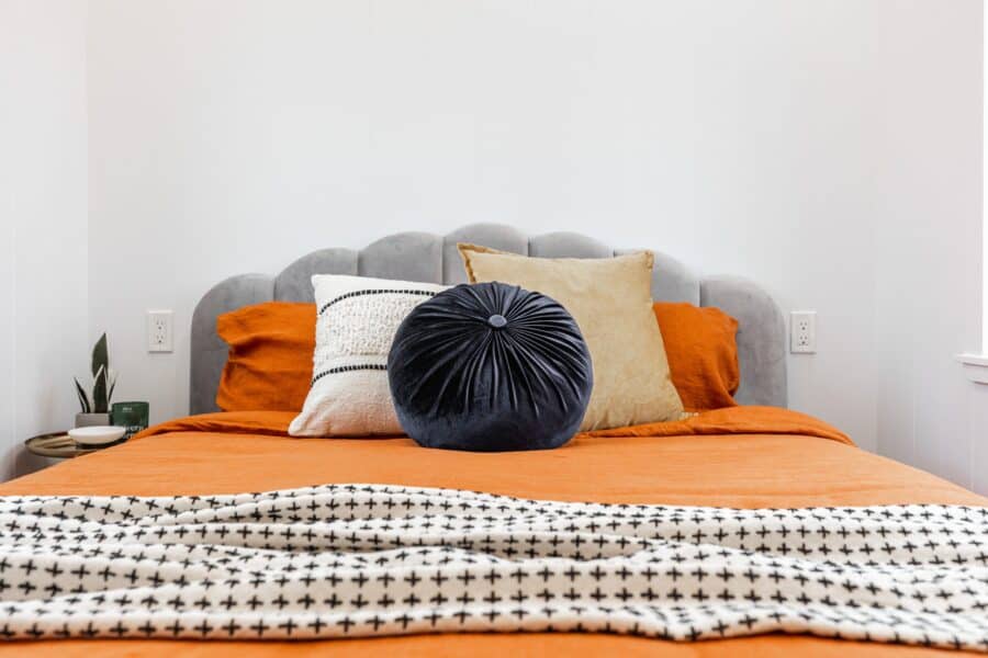 Comfortable tiny house bedroom with stylish pillows and soft bedding.