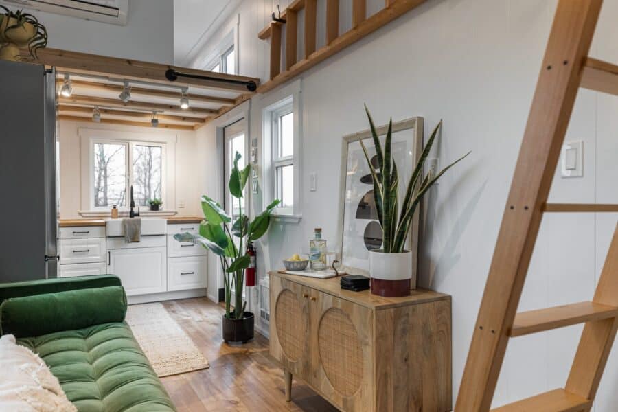 Cozy tiny house interior featuring a small kitchen and living space with natural light.