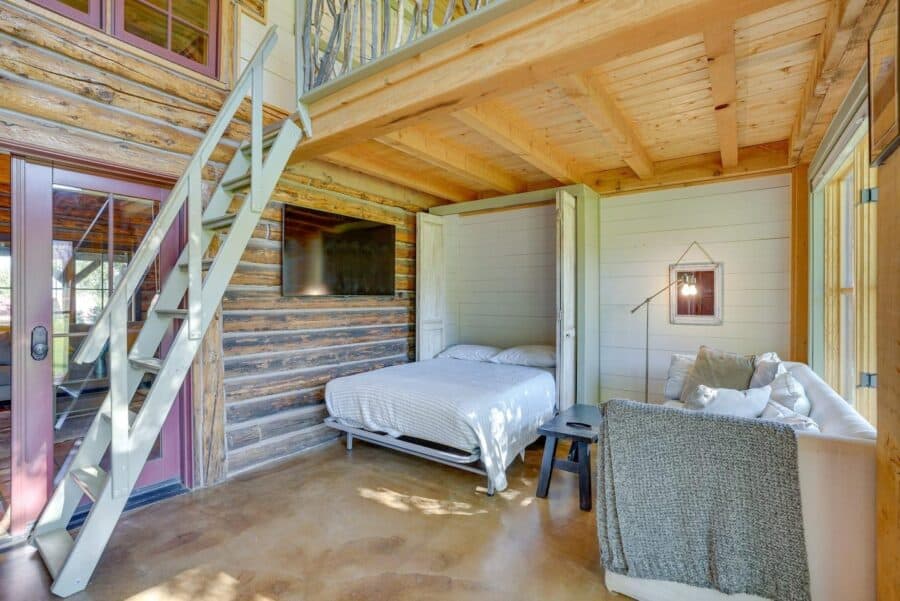 Charming log cabin bedroom featuring rustic wood walls, stone accents, and modern furnishings for a.