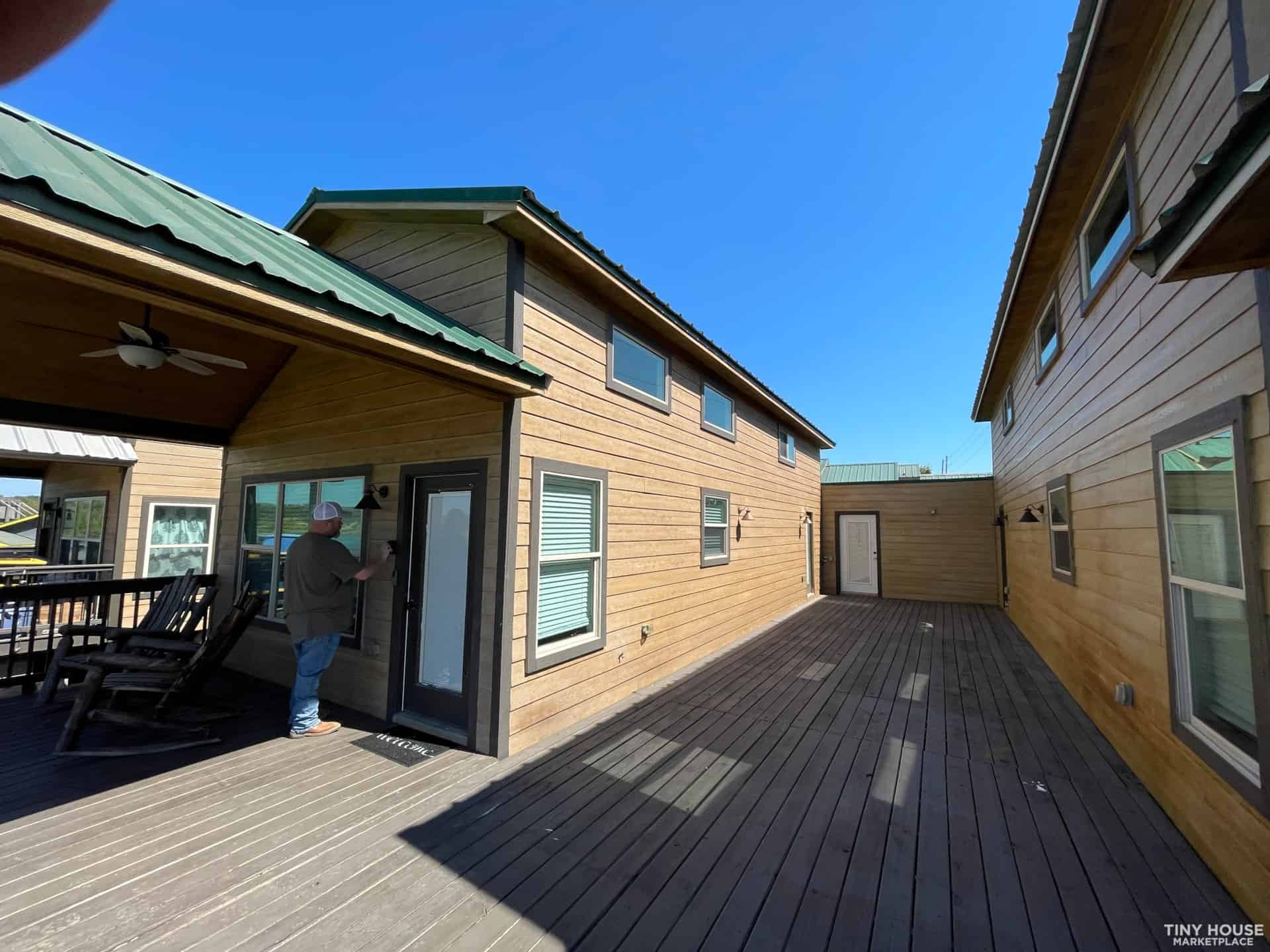 Bright tiny house with large windows and outdoor deck area.