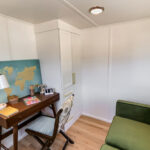 Small tiny house interior with a dedicated home office area and cozy seating.