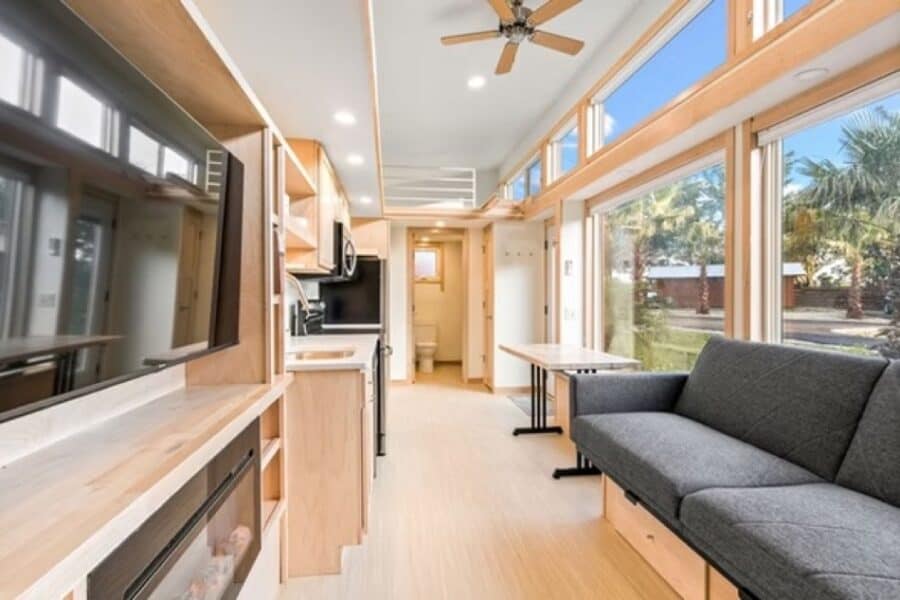 Bright tiny house living space with modern kitchen and comfortable seating area.