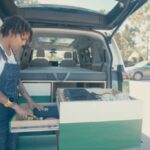 Woman organizing a compact van kitchen for tiny house living and van life adventures.