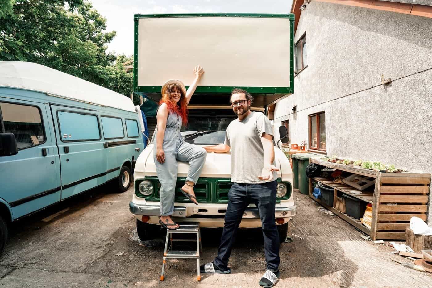 Lucy and Ben sitting on the front of their Bedford CF van during the conversion build