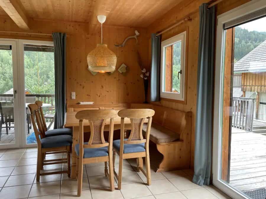 Cozy chalet cabin interior with wooden furniture and mountain views in Austria.