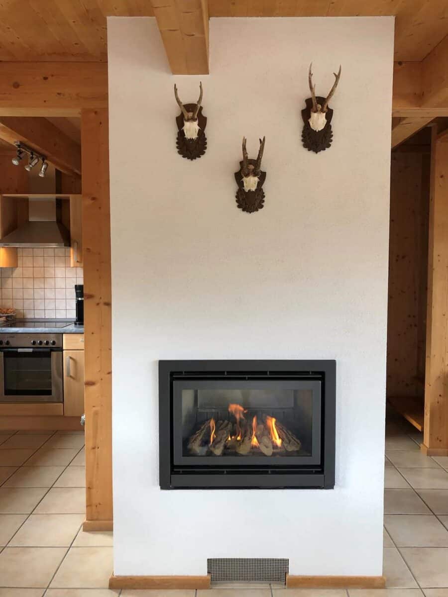 Fireplace with mounted deer head decor in a cozy chalet-style interior.