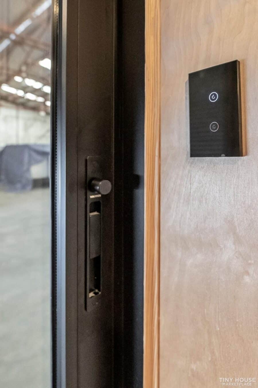 Modern interior door with smart control panel in a tiny house setting.
