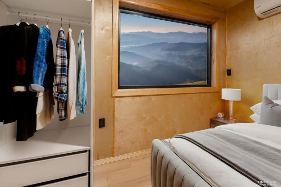 Modern shipping container home with scenic mountain view through large window.