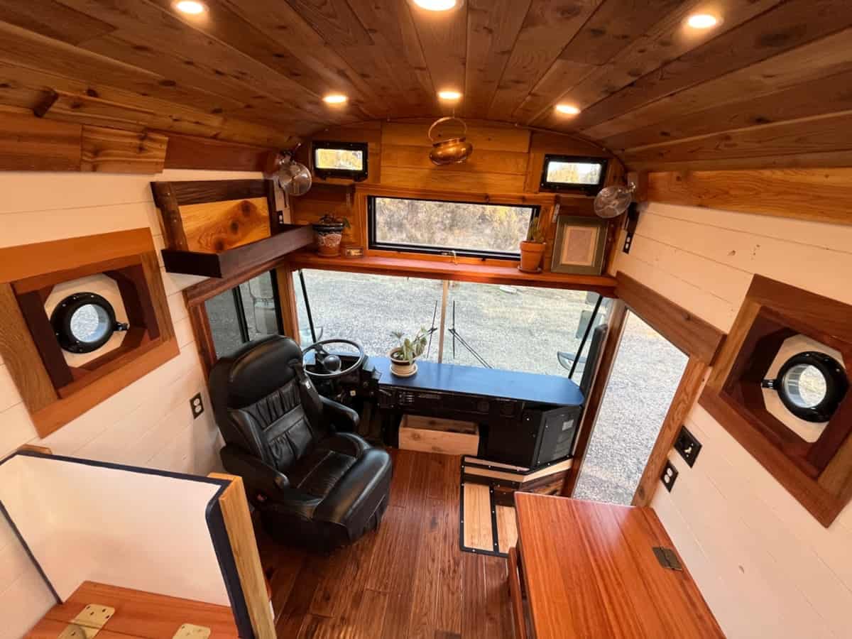 Driver area with leather captain chair hardwood dashboard surround and porthole windows