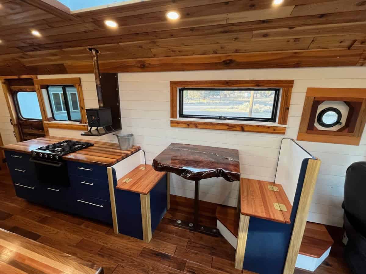 Kitchen and dining area with navy blue cabinets butcher block counters custom redwood burl dining table and wood stove