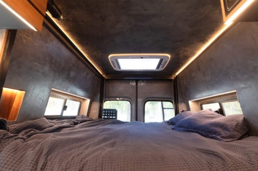 Compact van bedroom with skylight and modern interior design.