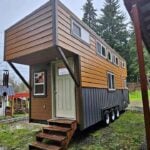 Tiny house on wheels with a contemporary wooden exterior and compact living space.