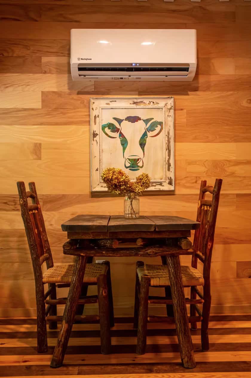Charming small dining space with rustic wooden table and chairs in a magical cabin setting.