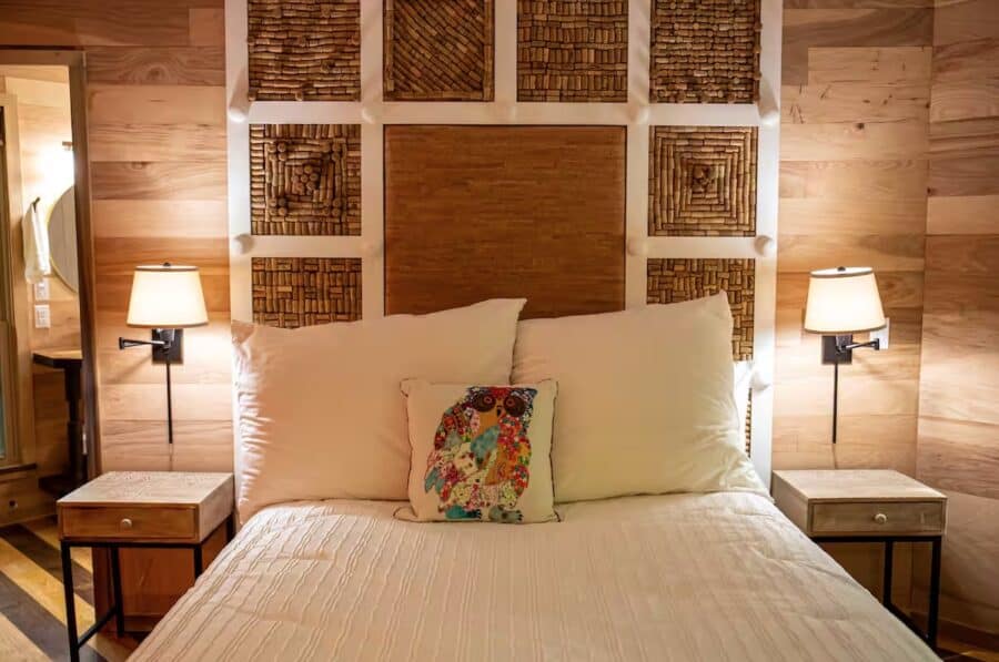 Charming cabin bedroom with wooden accents and unique wall art, perfect for a peaceful retreat in Me.