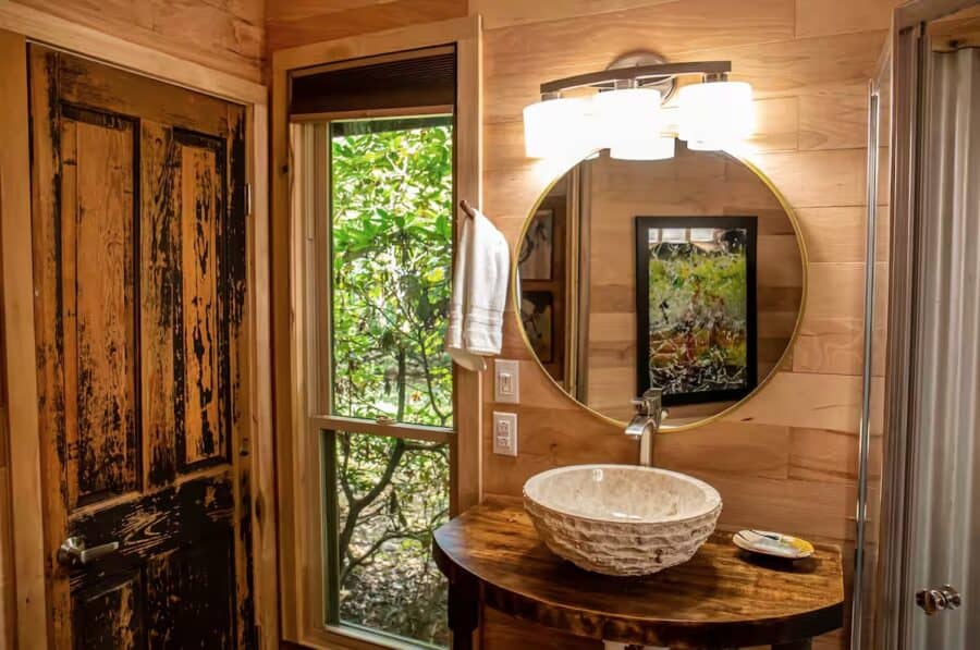 Charming cabin bathroom with rustic wooden accents and a natural stone sink, nestled in the woods of.