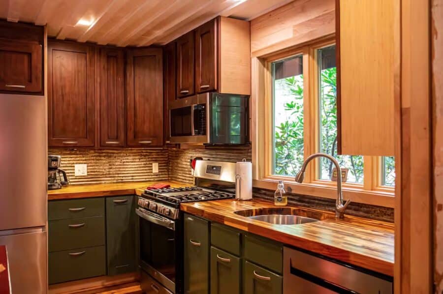 Kitchen interior with wooden cabinets and modern appliances in a tiny house.