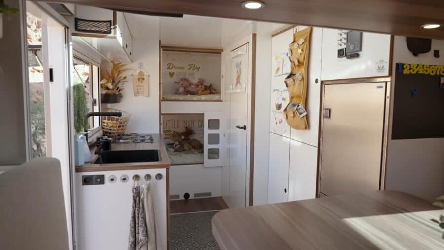 Cozy tiny house interior with compact kitchen and storage, perfect for overlanders.