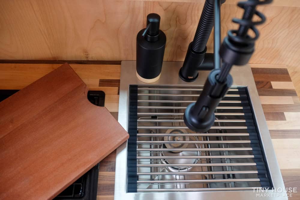 Compact kitchen sink with modern faucet in tiny house.