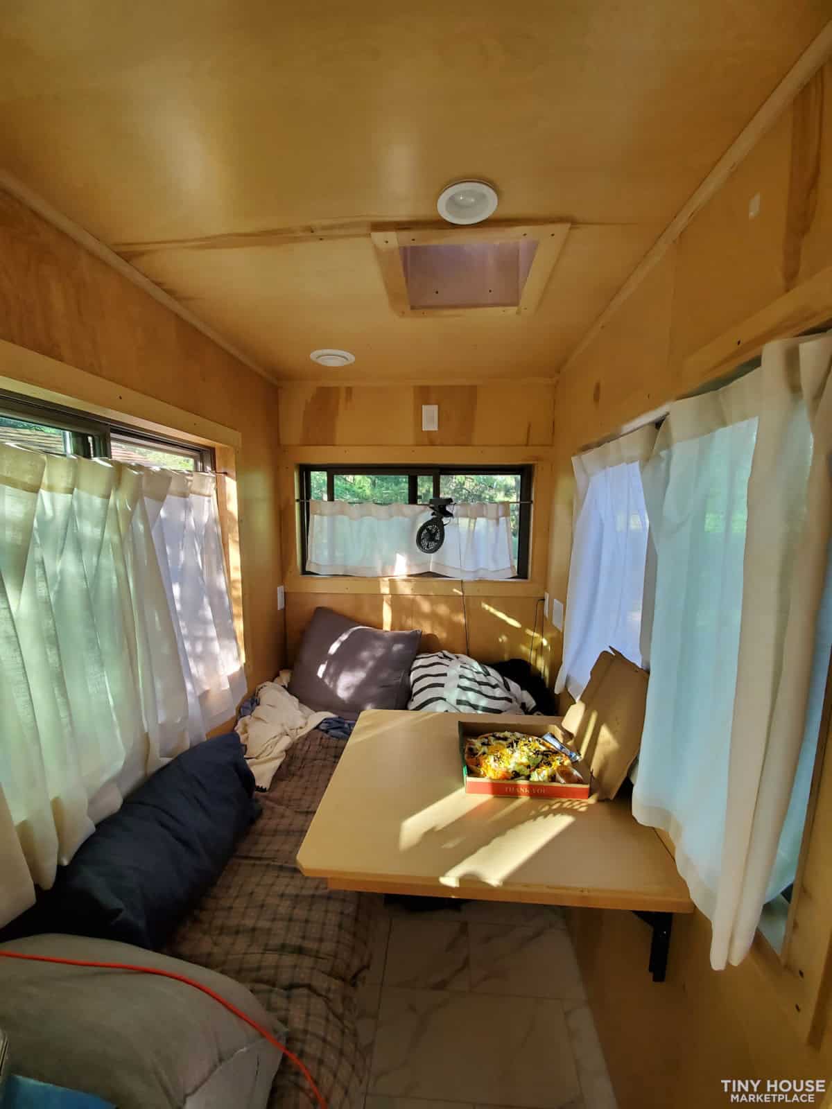 Compact tiny house living space with natural light and simple furnishings.