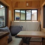 Small tiny house interior with cozy seating and large windows for natural light.