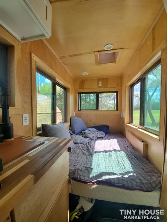 Cozy tiny house interior featuring large windows and a comfortable sleeping area. Perfect for small.