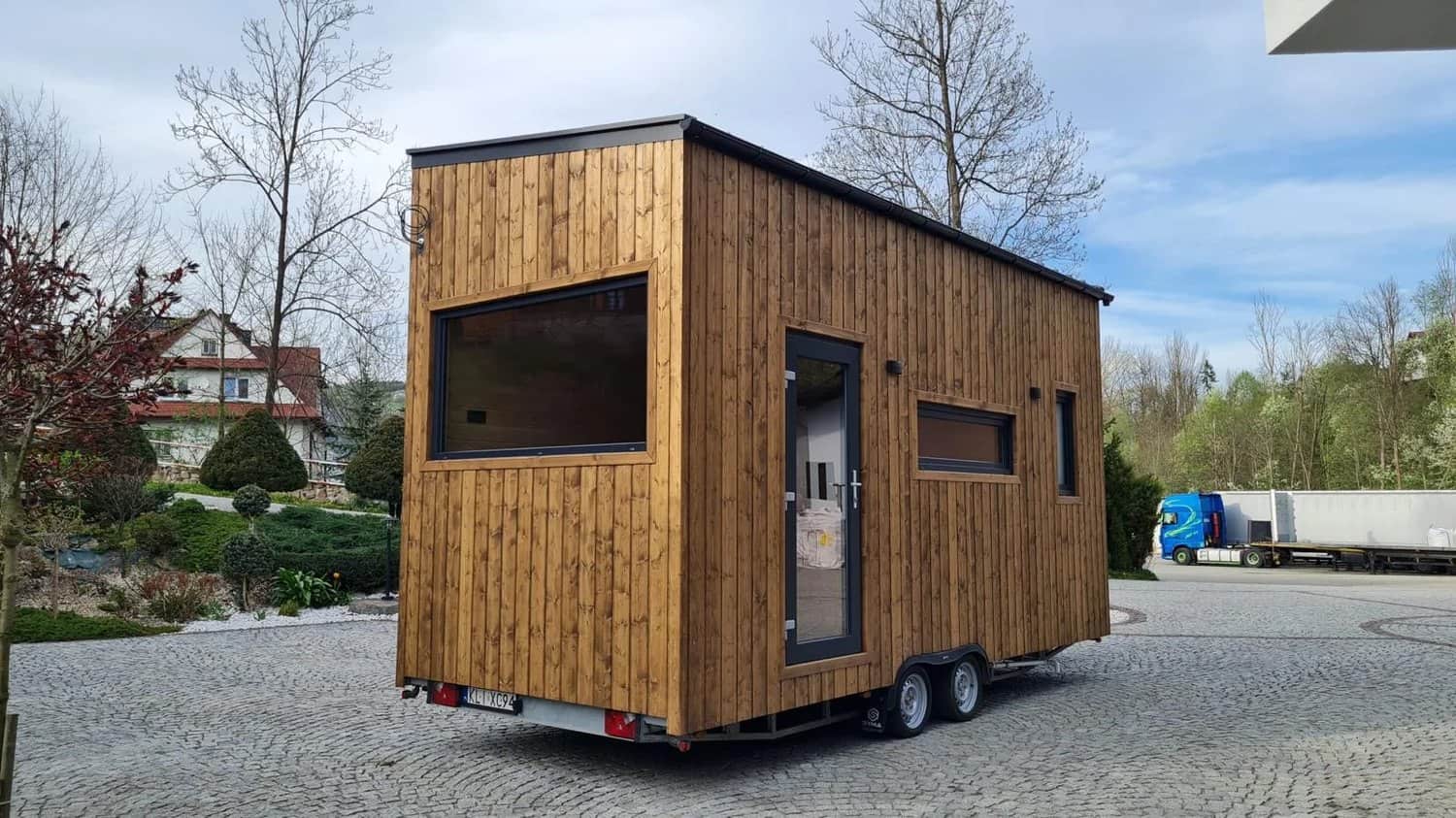The Mini tiny house by Craft House with torched-wood siding and a single-pitch roof, on its trailer