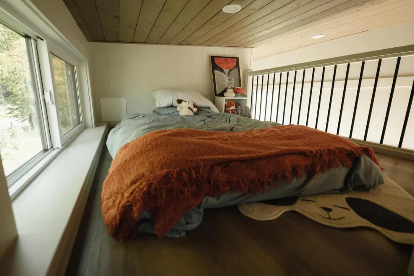 Second sleeping loft in the Mint Ventura with a black slat railing overlooking the main floor