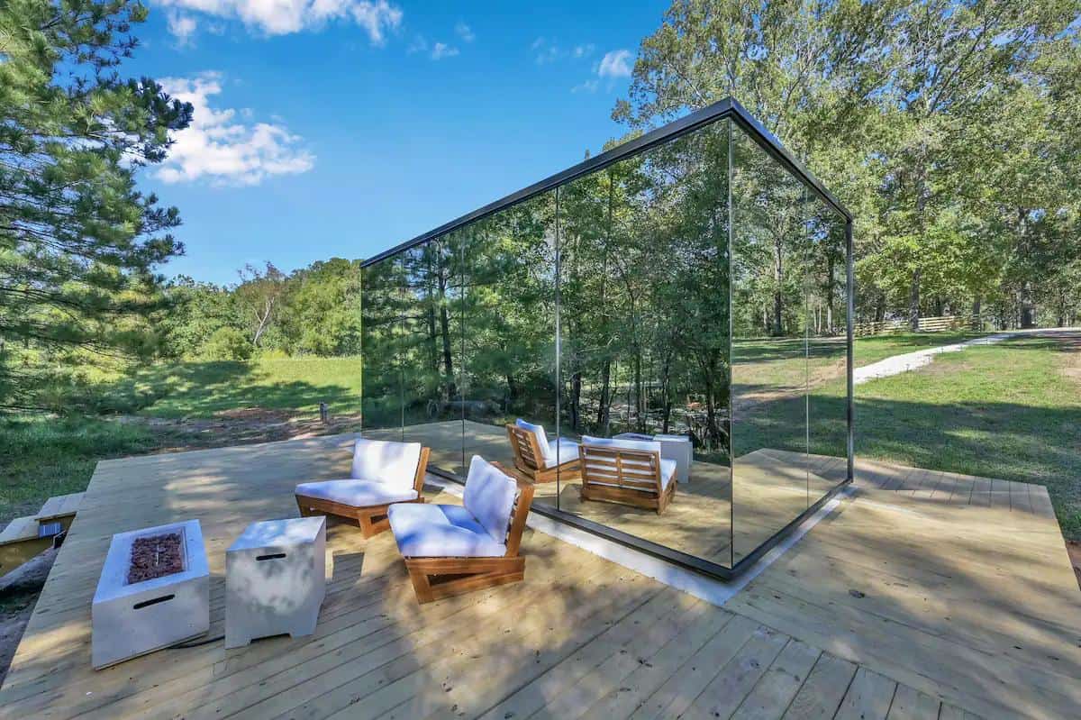 Mirror Cabin in Texas with outdoor bathtub and glass walls.